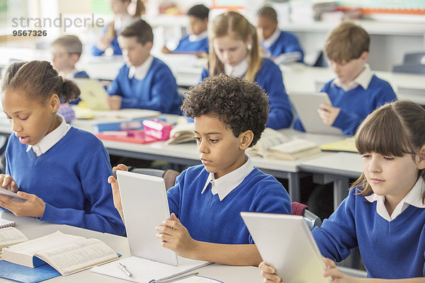 Grundschulkinder mit digitalen Tabletten im Klassenzimmer