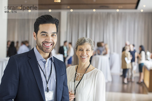 Porträt eines Mannes und einer Frau  die in der Lobby des Konferenzzentrums stehen  lächelnd