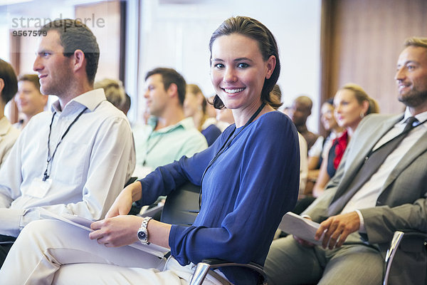 Porträt der lächelnden jungen Frau  die im Konferenzraum sitzt