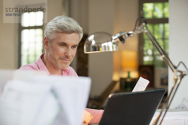 Älterer Mann mit Laptop im Home-Office