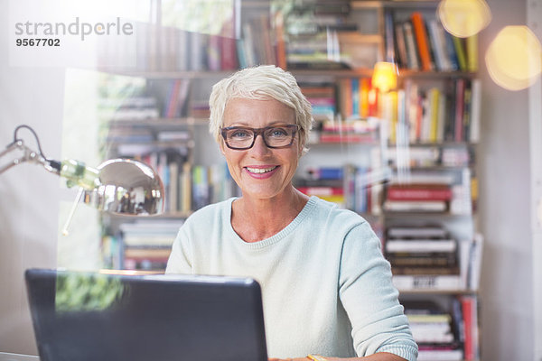 Geschäftsfrau lächelt am Computer im Home-Office