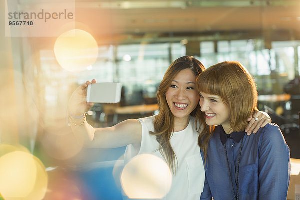 Geschäftsfrauen nehmen Handy-Selfie im Büro mit