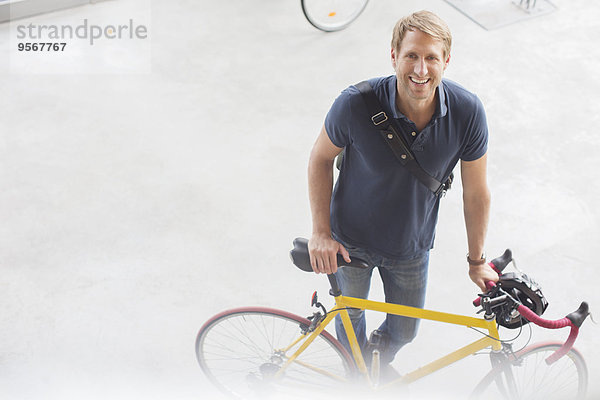Lächelnder Mann stehend mit Fahrrad