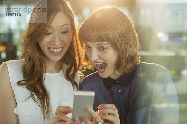 Geschäftsfrauen mit dem Handy im Büro