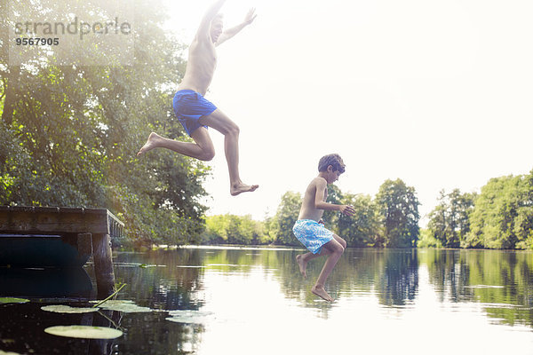 Vater und Sohn springen in den See