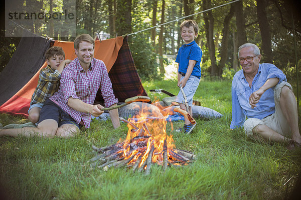 Junge  Vater und Großvater entspannen am Lagerfeuer