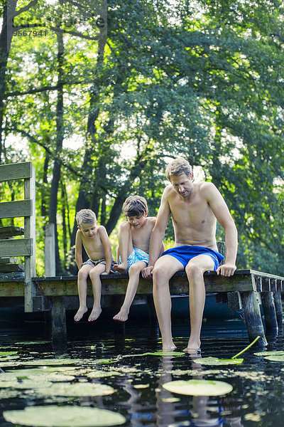 Vater und Söhne baumeln im See