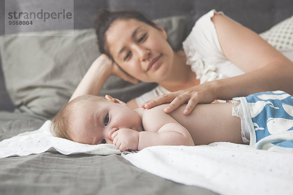 Porträt eines kleinen Babys mit lächelnder Mutter im Hintergrund