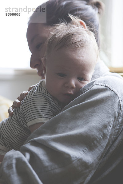 Porträt der Mutter mit dem kleinen Baby im gestreiften T-Shirt