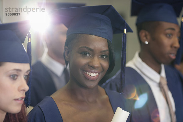 Porträt eines Universitätsstudenten mit Diplom während der Abschlussfeier