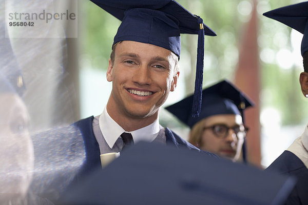 Porträt eines lächelnden Studenten bei der Abschlussfeier