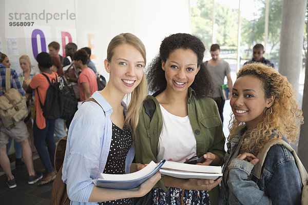 Porträt von Universitätsfreunden im Flur mit Büchern