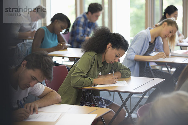 Blick auf die Schüler  die während des Tests im Klassenzimmer am Schreibtisch sitzen