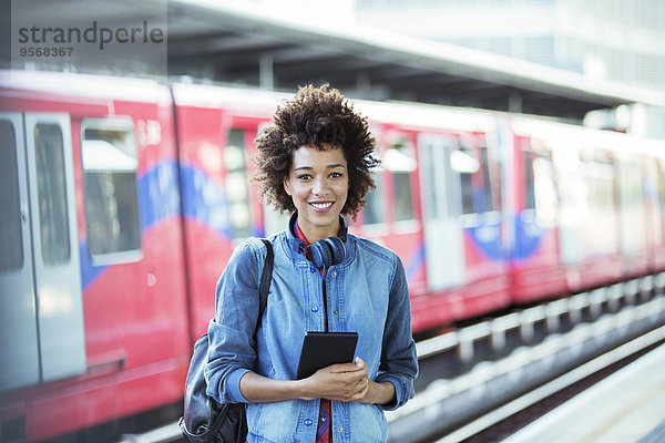 Lächelnde Frau im Bahnhof stehend