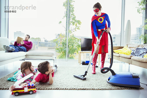 Superhelden saugen im Wohnzimmer um die Familie herum