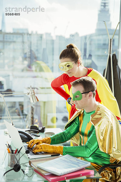 Superhelden bei der Arbeit am Laptop im Büro