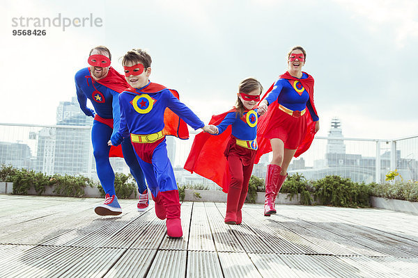 Superheldenfamilie spielt auf dem Stadtdach