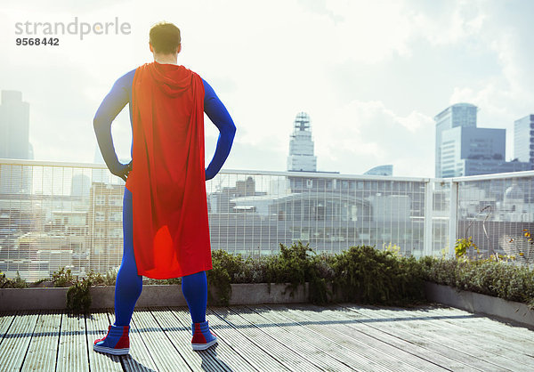 Superheld mit Blick vom Stadtdach aus