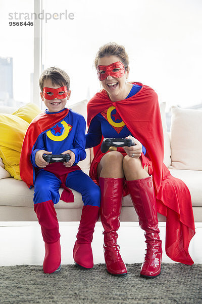 Superheld Mutter und Sohn beim Videospiel im Wohnzimmer