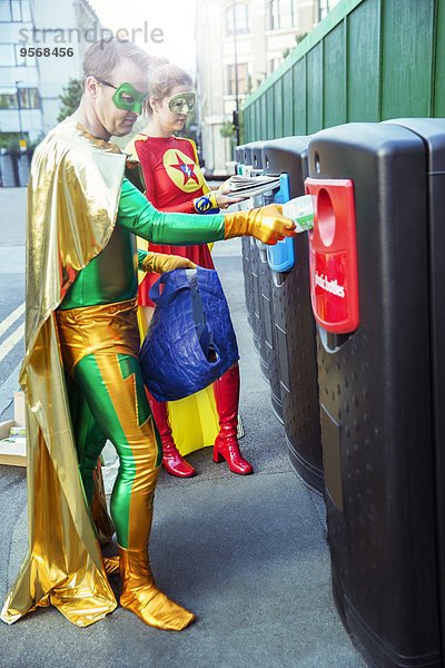 Superheldenpaar Recycling auf dem Bürgersteig der Stadt