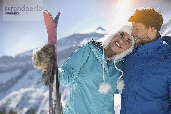 Pärchen mit Skiern am Berg