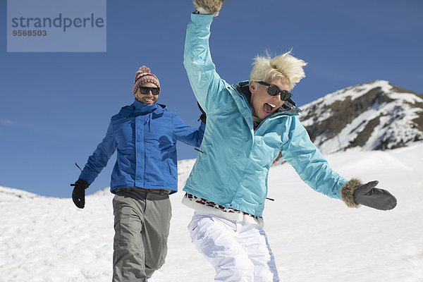 Überschwängliches Paar beim Spielen im Schnee