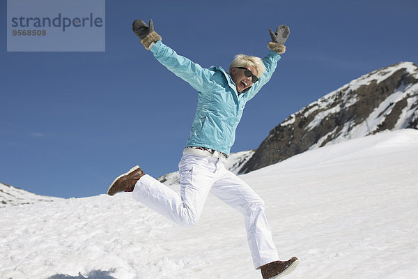 Überschwängliche Frau beim Spielen im Schnee