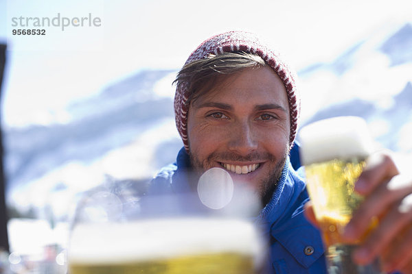 Porträt eines Mannes  der im Freien Bier trinkt
