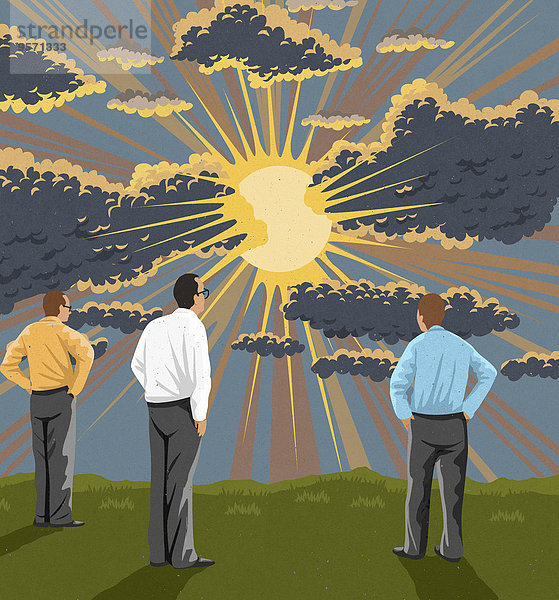 Drei Geschäftsmänner schauen auf Sonnenstrahlen hinter Regenwolken