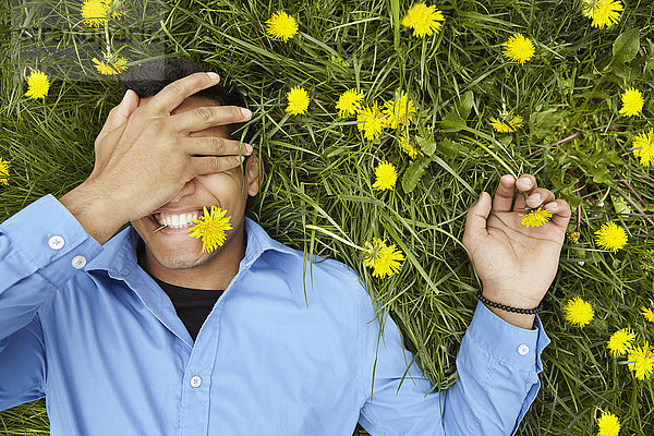 liegend liegen liegt liegendes liegender liegende daliegen Mann Blume lächeln Feld