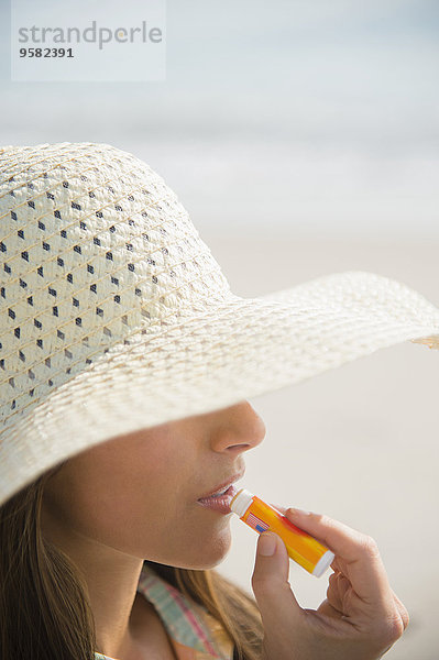 eincremen verteilen Europäer Frau Strand Sonnencreme Zitronenmelisse auftragen