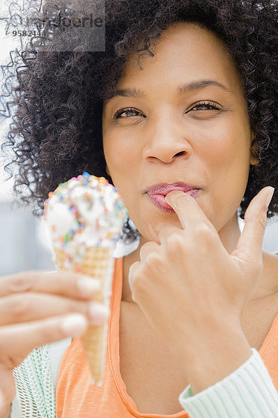 kegelförmig Kegel Frau lächeln Eis essen essend isst Sahne
