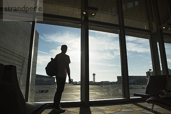 Mann Fenster Silhouette Flughafen hinaussehen