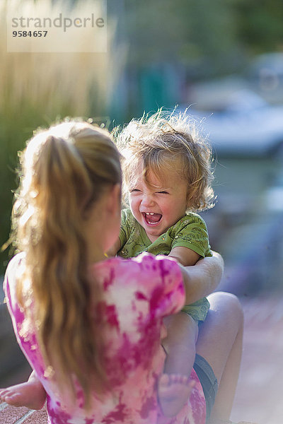 Außenaufnahme Europäer lachen Bruder Schwester halten Baby freie Natur