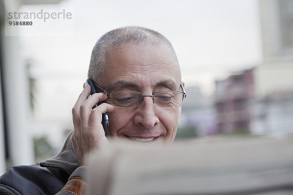 Handy Senior Senioren Mann sprechen Hispanier Zeitung vorlesen
