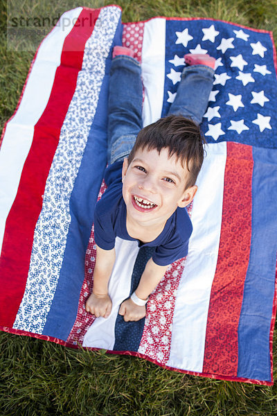 liegend liegen liegt liegendes liegender liegende daliegen Junge - Person Decke mischen Fahne amerikanisch Gras Mixed