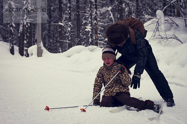 fallen fallend fällt Europäer Menschlicher Vater Hilfe Skisport Tochter querfeldein Cross Country Schnee