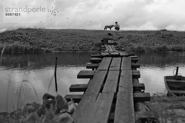 nahe überqueren Hund Ländliches Motiv ländliche Motive Fluss streicheln Holzbrücke Mädchen