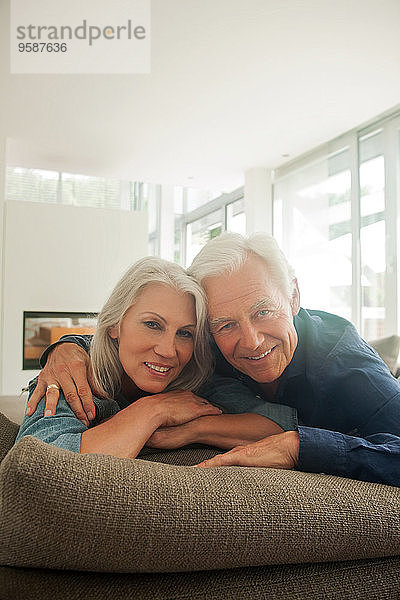 Porträt eines lächelnden Seniorenpaares  das seine Zeit zu Hause verbringt
