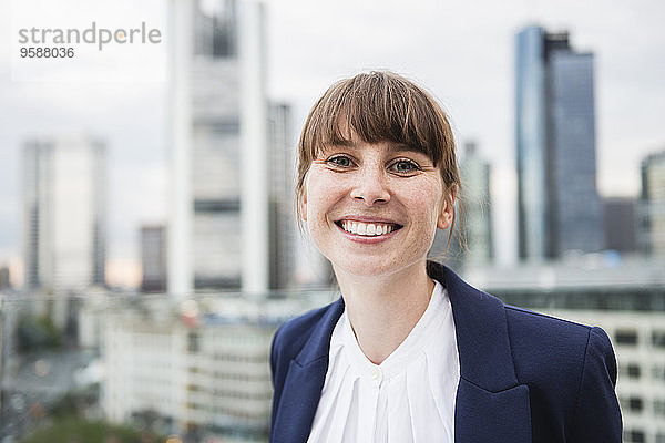 Deutschland  Hessen  Frankfurt  Porträt einer lächelnden Geschäftsfrau vor der Skyline