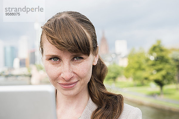 Deutschland  Hessen  Frankfurt  Portrait einer lächelnden Geschäftsfrau mit digitalem Tablett