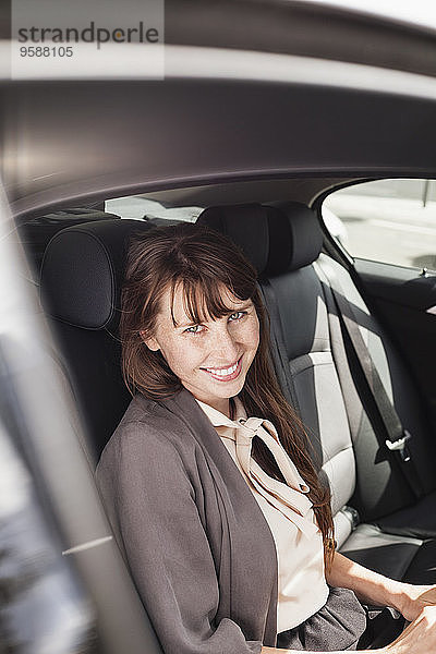 Deutschland  Porträt der lächelnden Geschäftsfrau im Auto