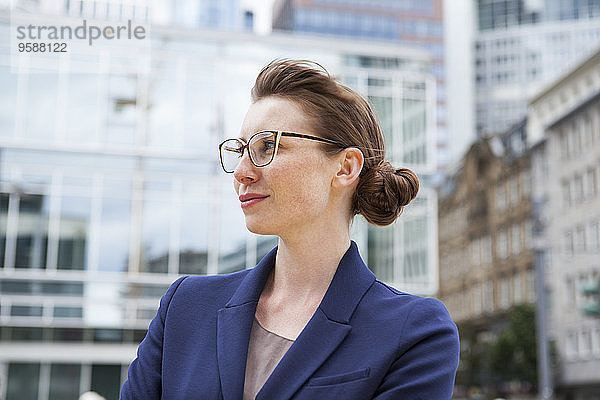 Deutschland  Hessen  Frankfurt  Porträt der lächelnden Geschäftsfrau vor Bürogebäuden