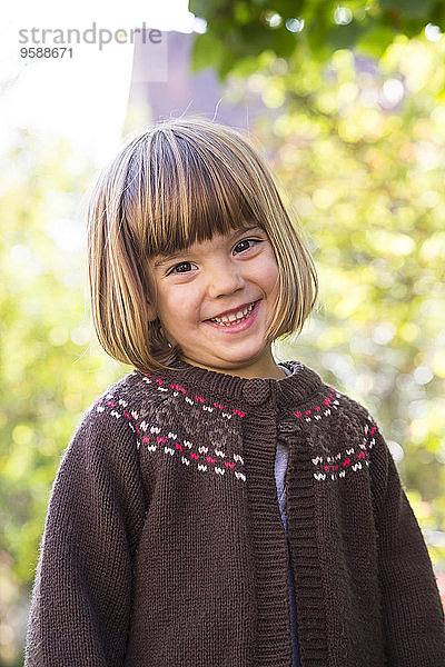 Porträt eines lächelnden kleinen Mädchens mit brauner Strickjacke