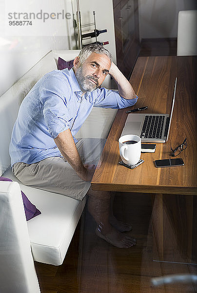 Porträt eines Geschäftsmannes mit Laptop im Home-Office