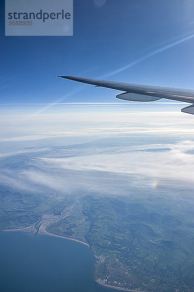 Linker Flügel einer Boeing 777-200 über der irischen Westküste bei Sonnenaufgang