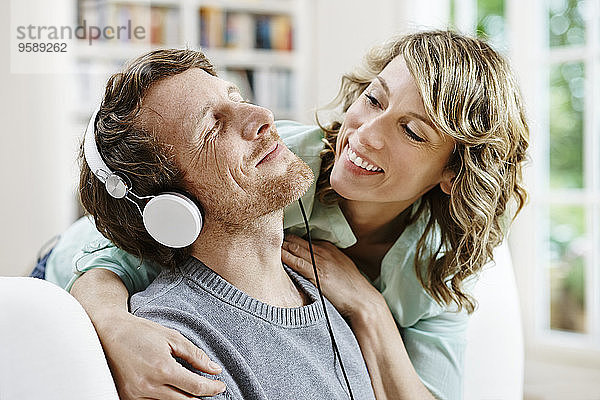Deutschland  Hessen  Frankfurt  Erwachsenenpaar zu Hause beim Musik hören