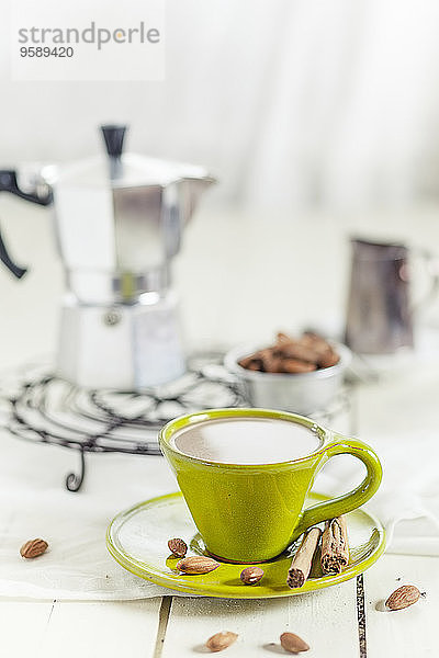 Tasse Kaffee mit Mandelmilch  Mandeln und Zimtstangen