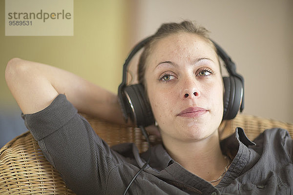 Porträt einer jungen Frau  die Musik mit Kopfhörer hört