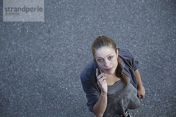 Junge Frau telefoniert mit Smartphone  Blick von oben